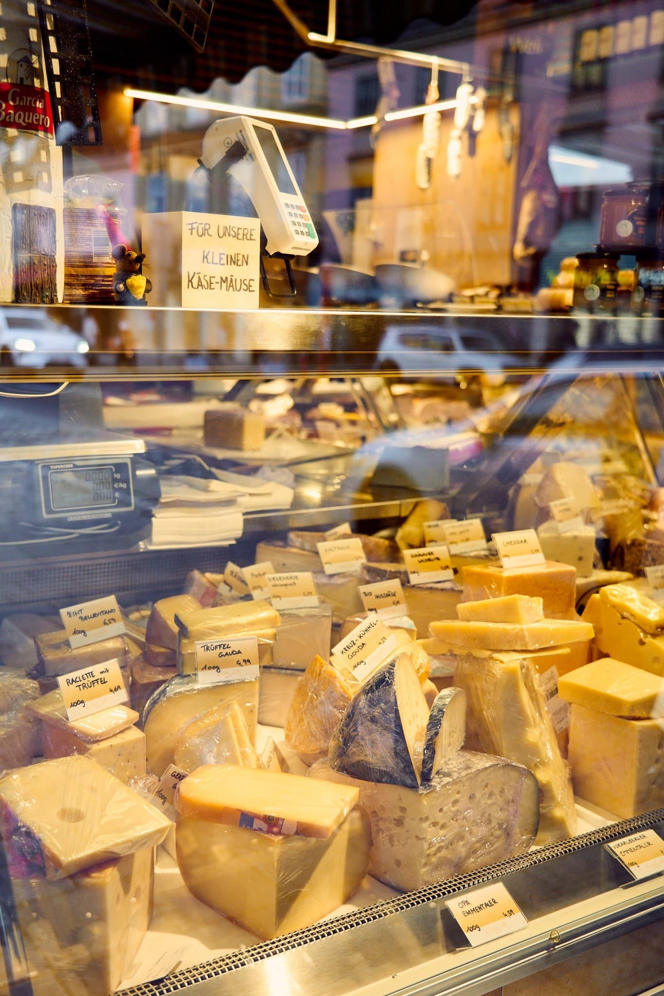 Outdoor market street with cheese stalls and browsing shoppers