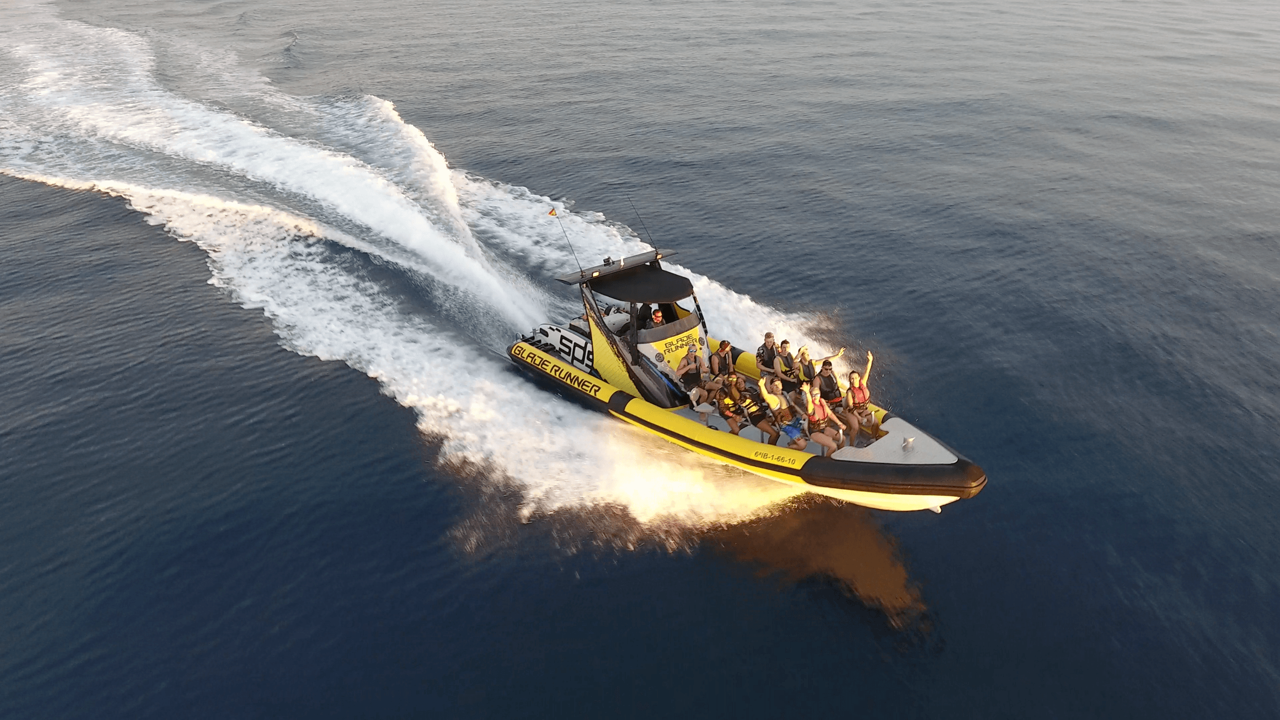 High-speed powerboat making dramatic wake on deep blue ocean