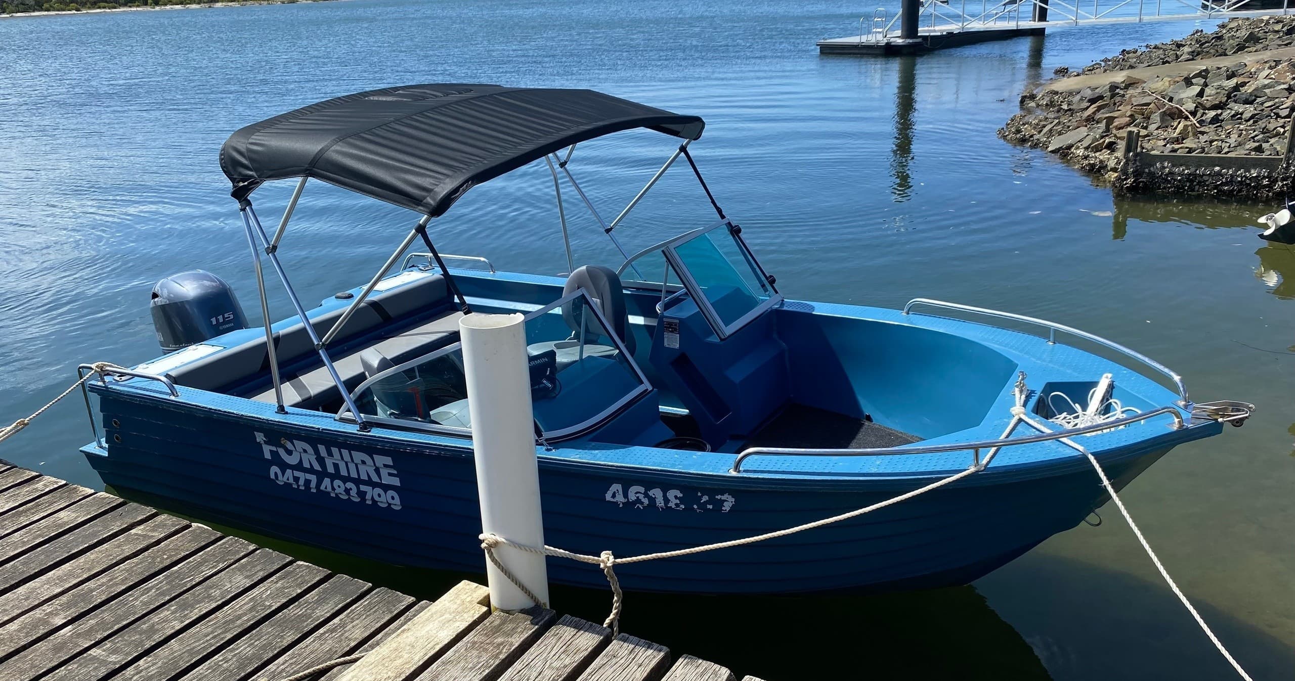 Hire motorboat moored at marina showcasing calm coastal waters