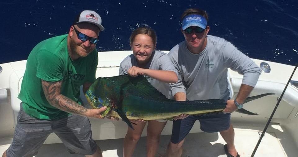 Anglers displaying mahi-mahi catch on offshore sportfishing boat