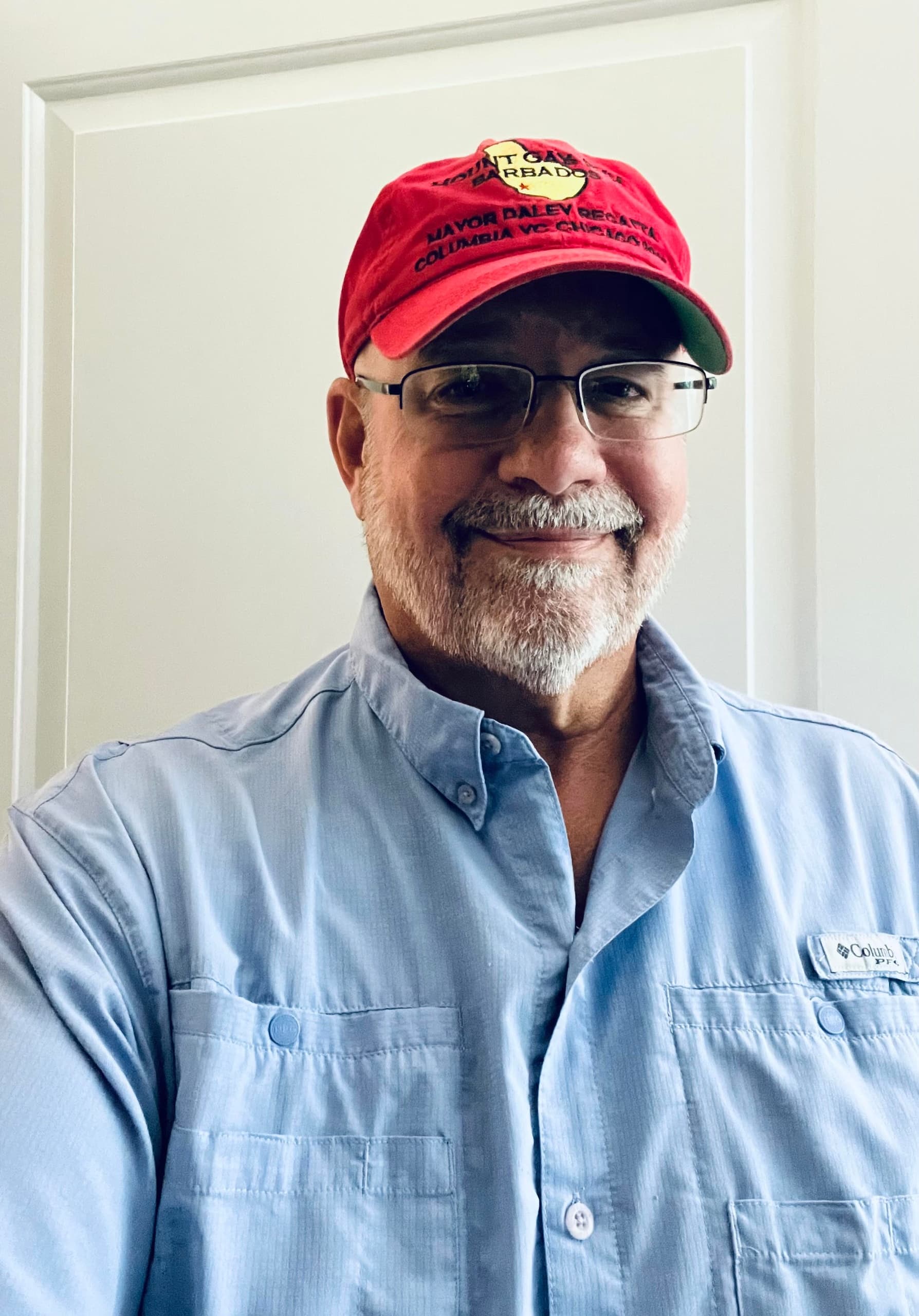 Captain portrait wearing hat and glasses, indoor headshot