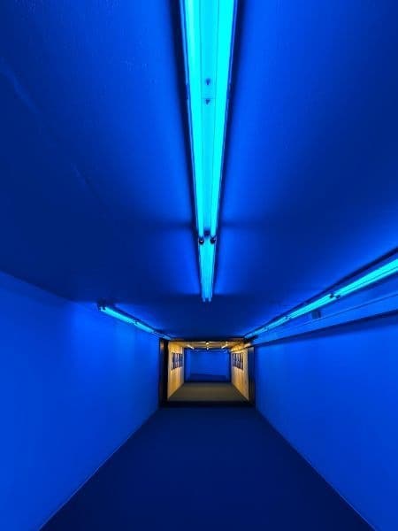 Blue-lit underground tunnel corridor for immersive urban walk and art