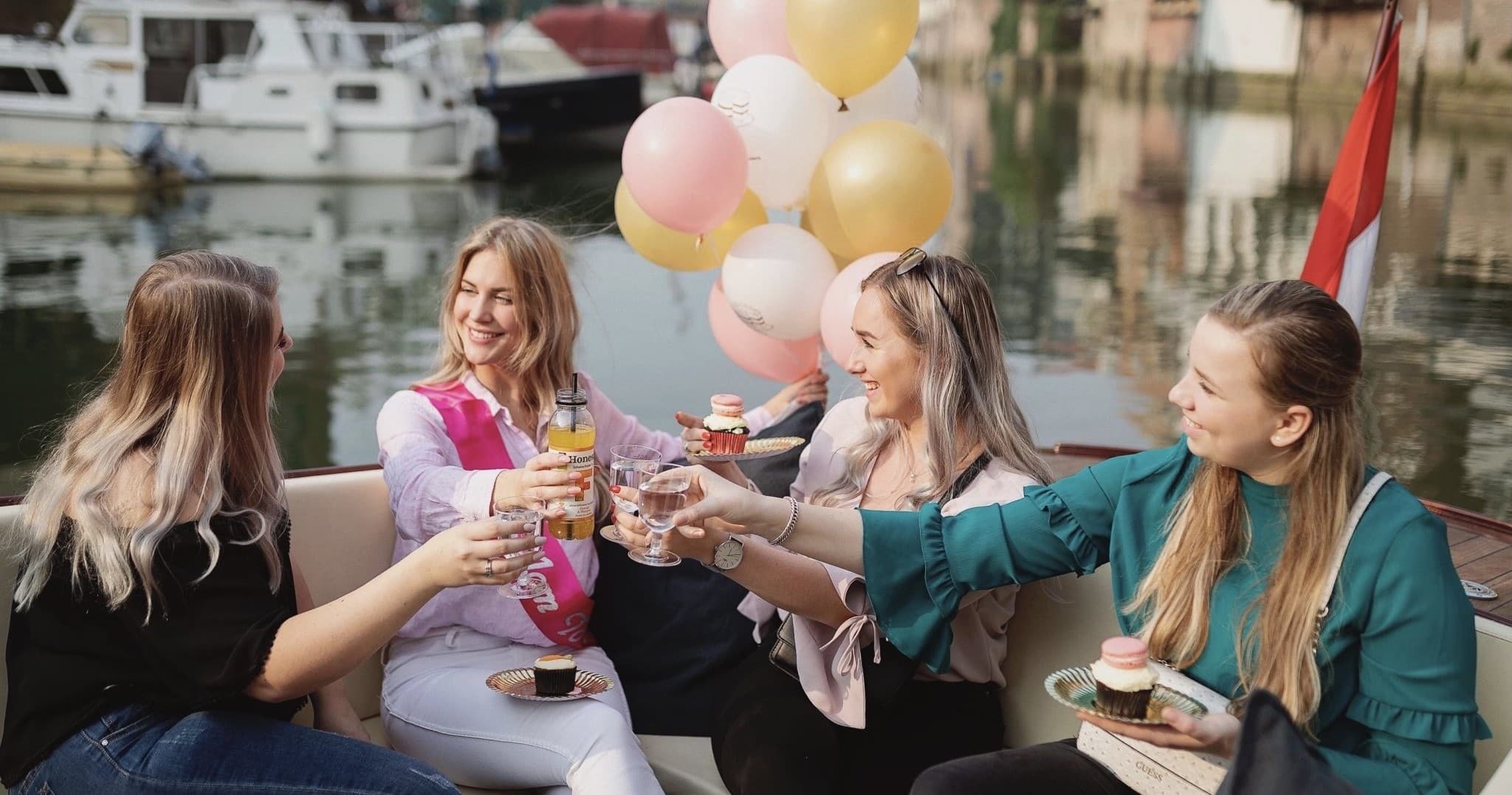 Friends enjoying private canal boat cruise with balloons and drinks