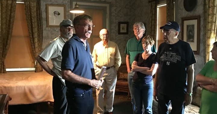 Guided tour group inside historic parlor at Grant Cottage museum