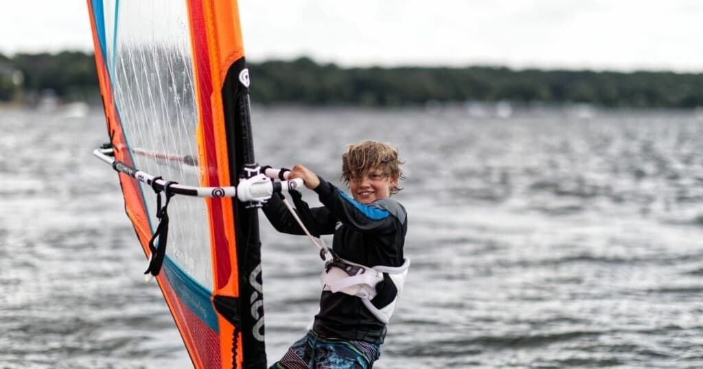 Windsurfer carving across choppy lake water on a windy day