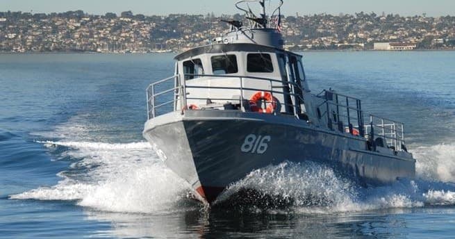 High-speed patrol boat cutting wake near San Diego shoreline