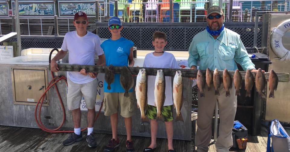 Group saltwater fishing charter showing anglers with multiple catches
