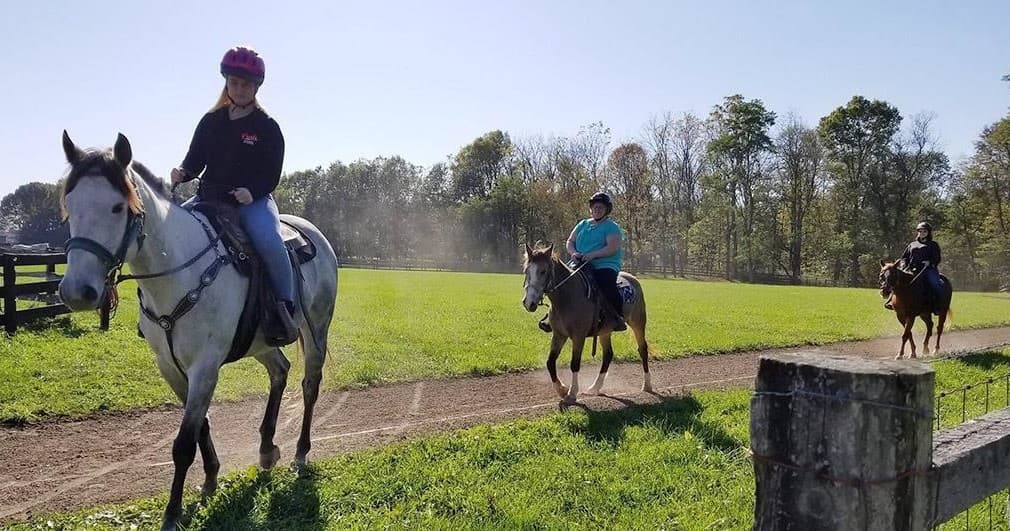 Horseback riders on scenic country trail at equestrian center