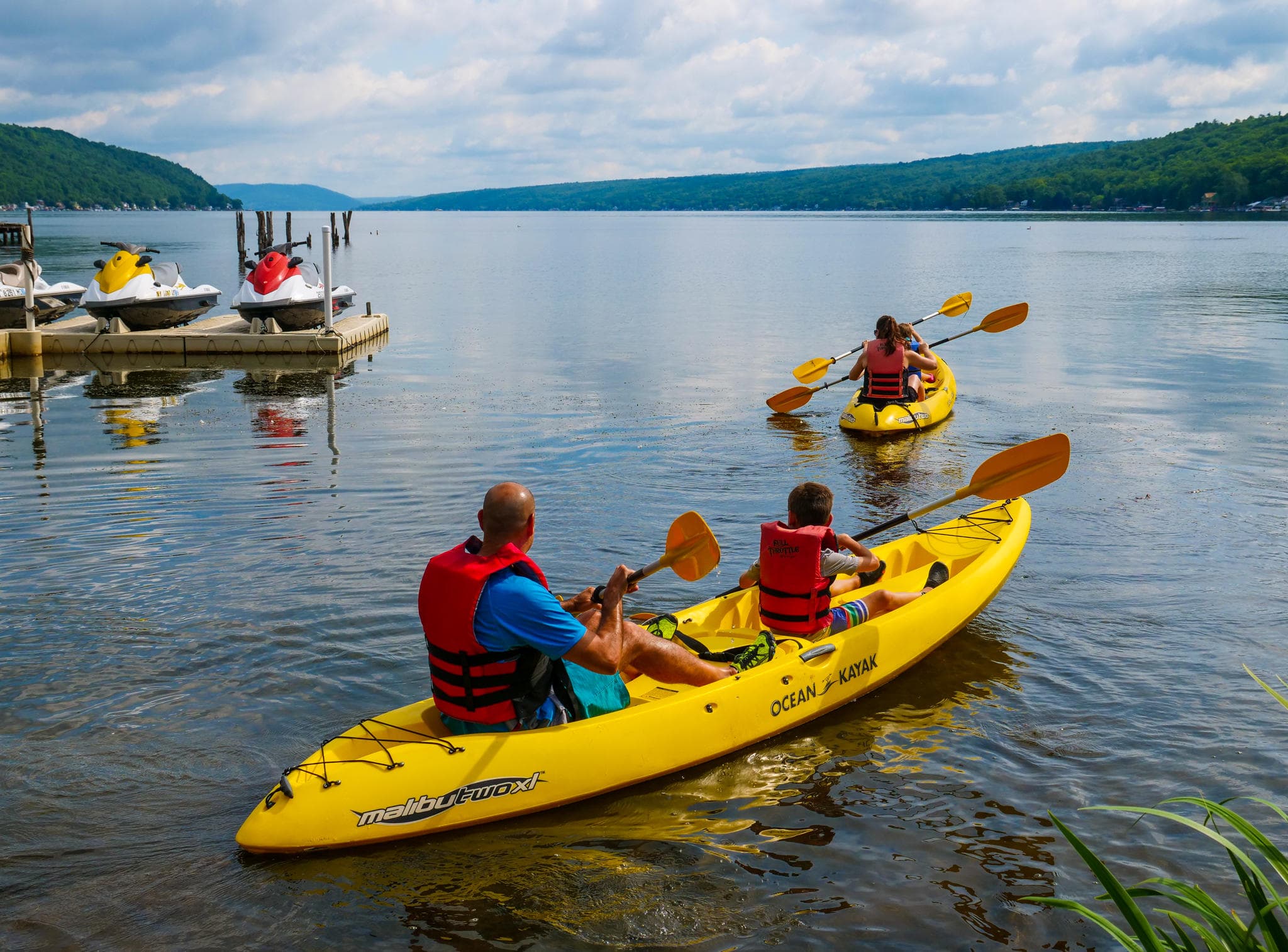Kayakers paddling on calm mountain lake with scenic views