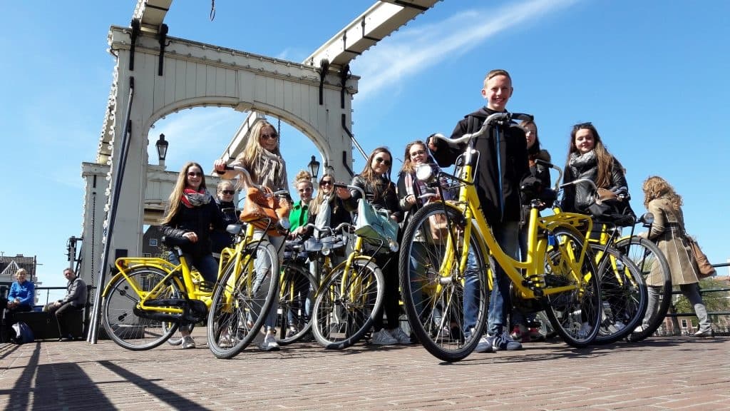 Group of cyclists on yellow rental bikes at city waterfront