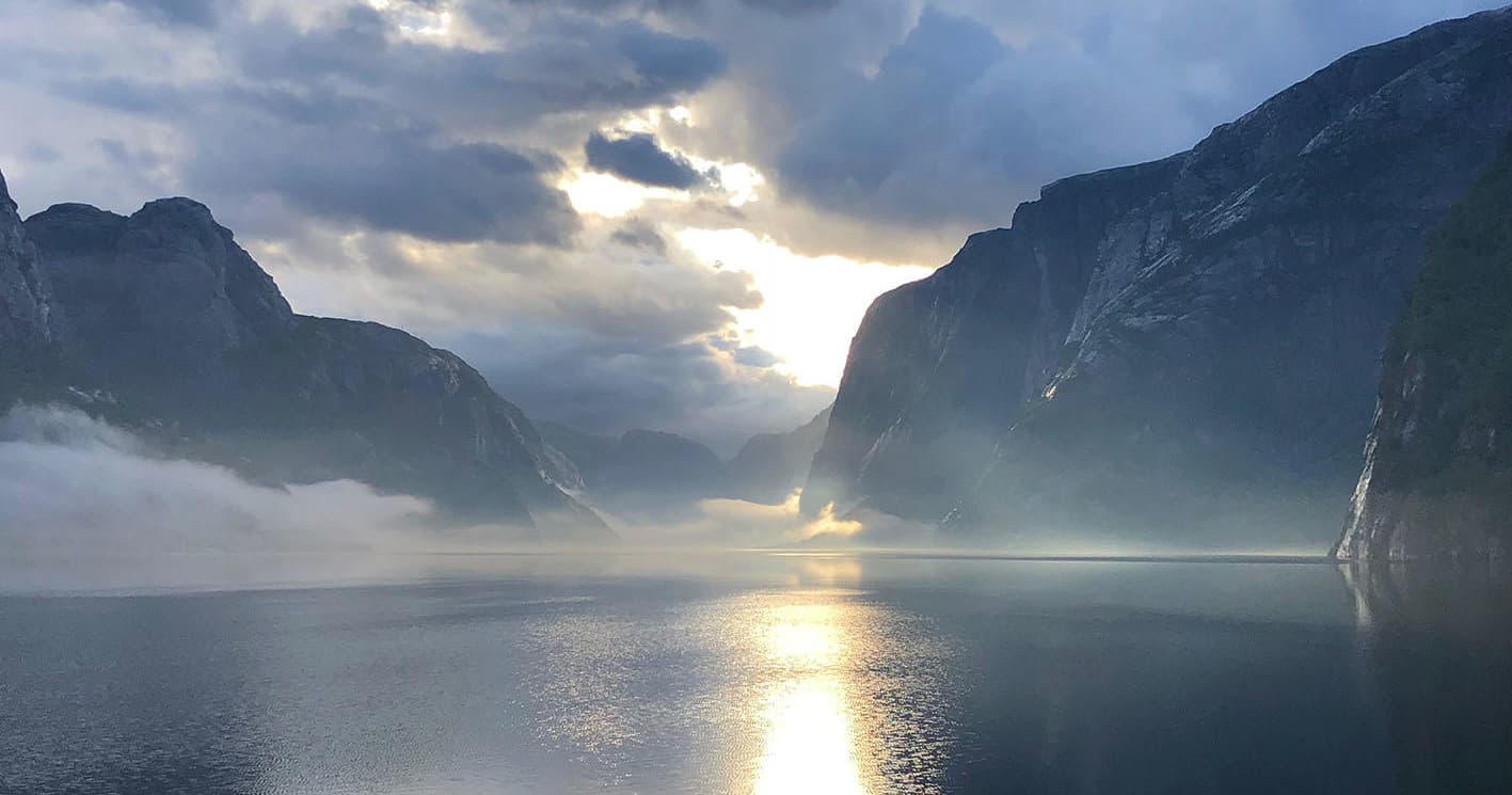 Foggy morning light over Lysefjord with calm reflective fjord waters