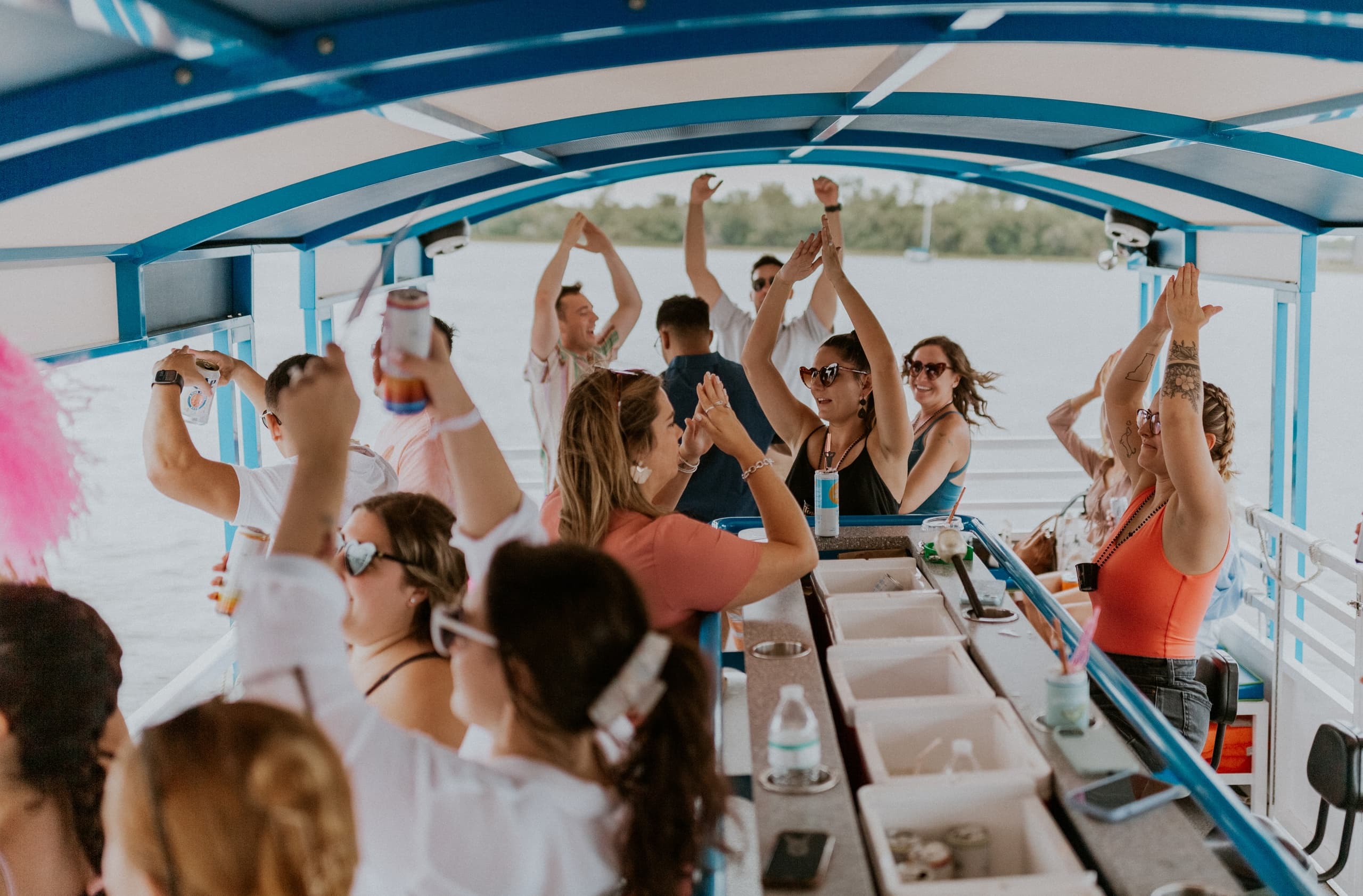 People dancing on a covered party boat cruise on open lake