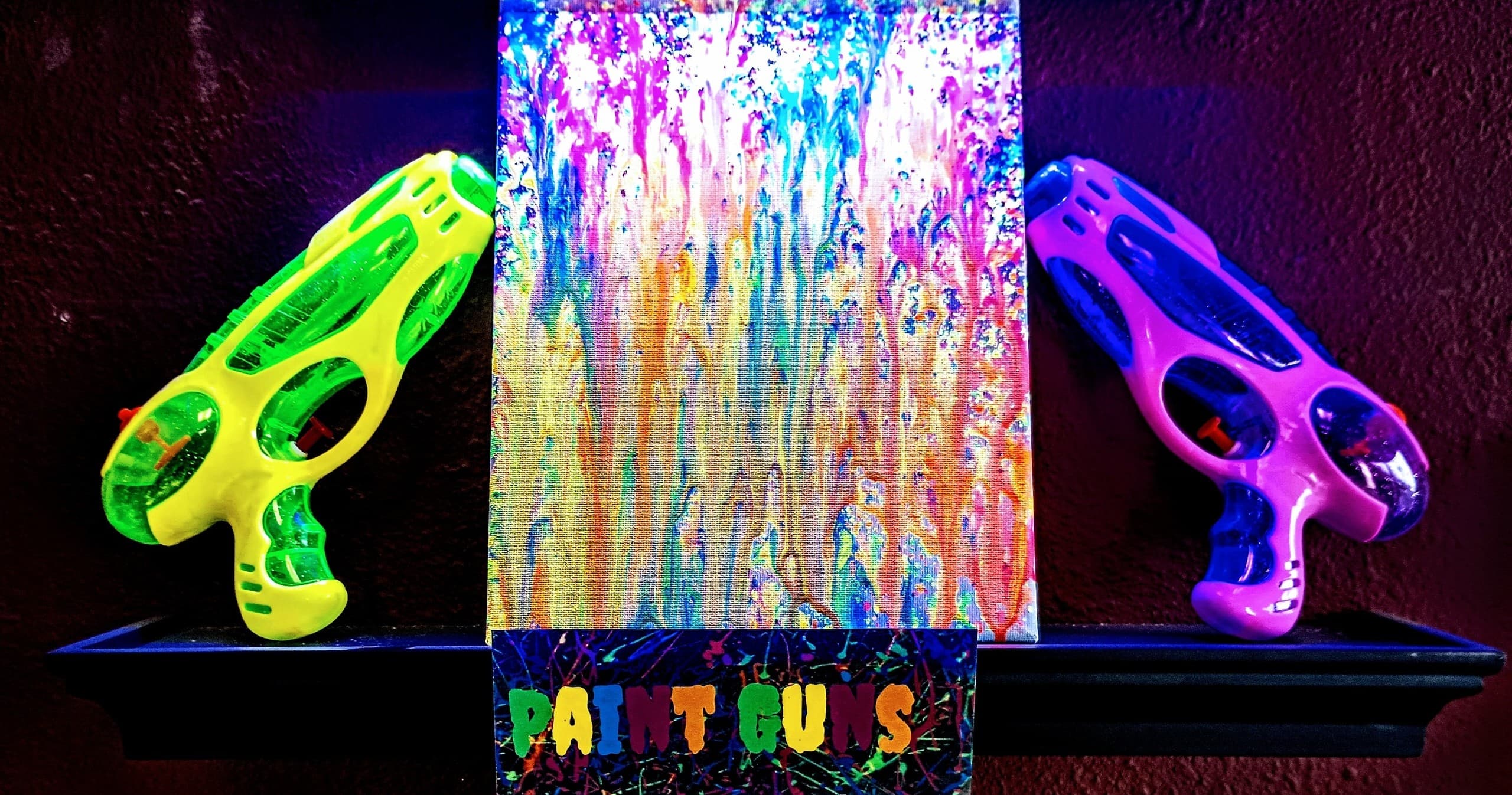 Neon paintball style pistols displayed in blacklight indoor paint studio