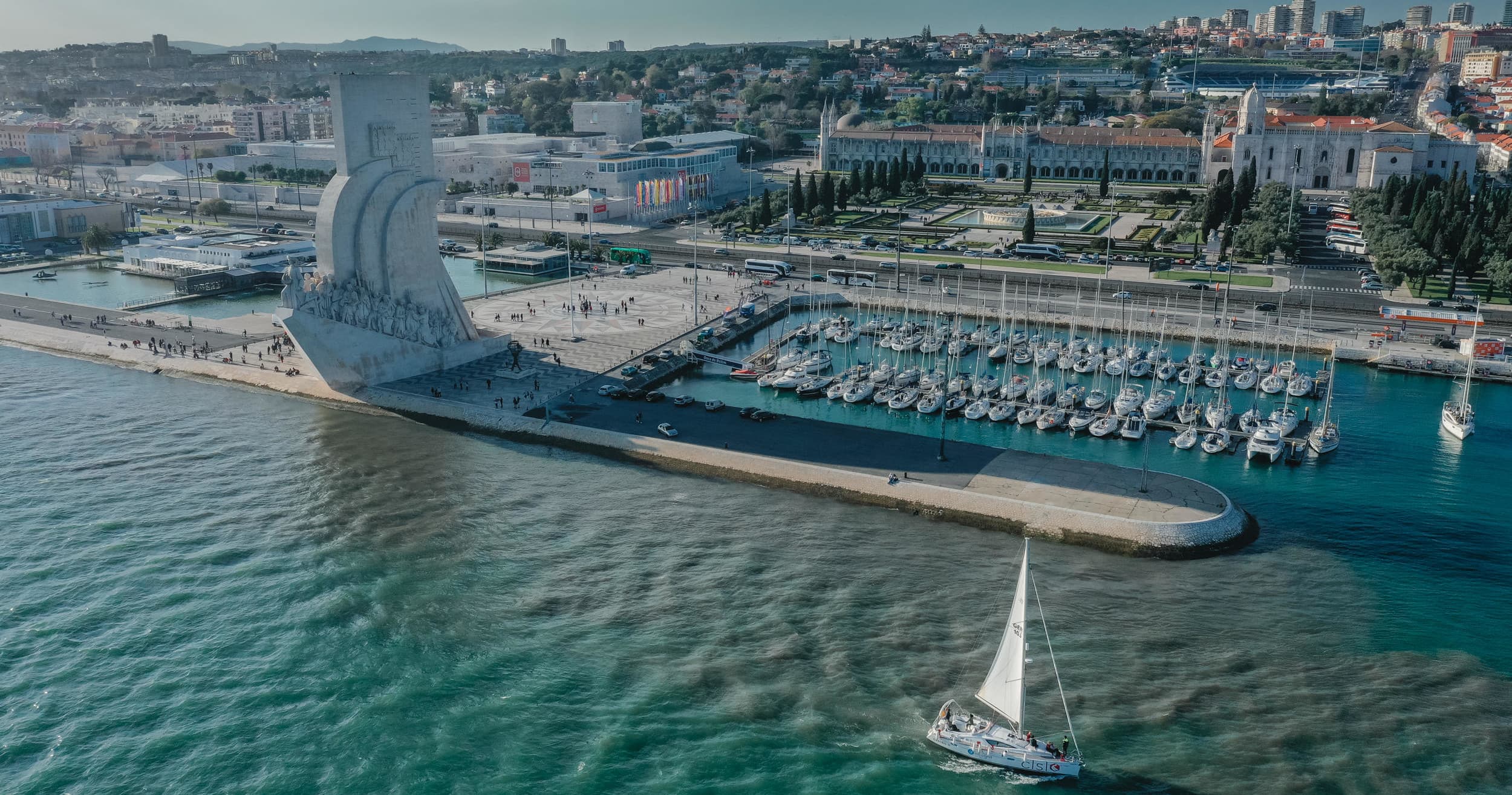 Aerial sailboat and Lisbon waterfront at Tagus River harbor