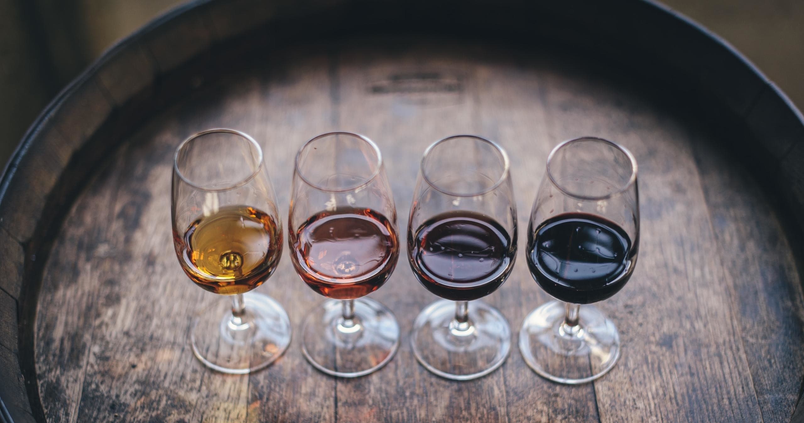 Flight of four wine samples arranged on wooden barrel