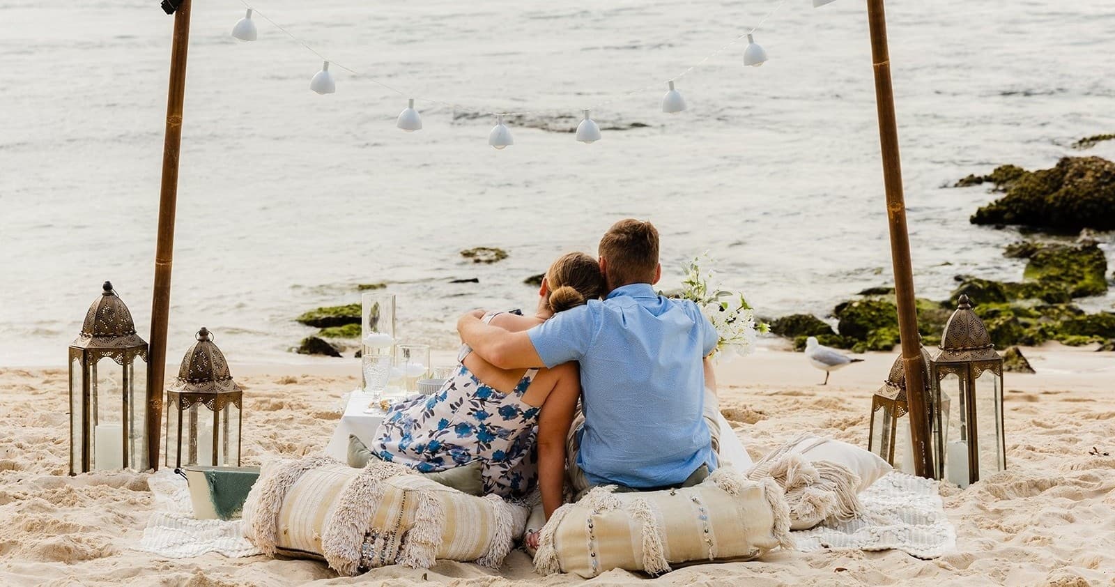 Couple cuddling on beach under canopy at Port Stephens
