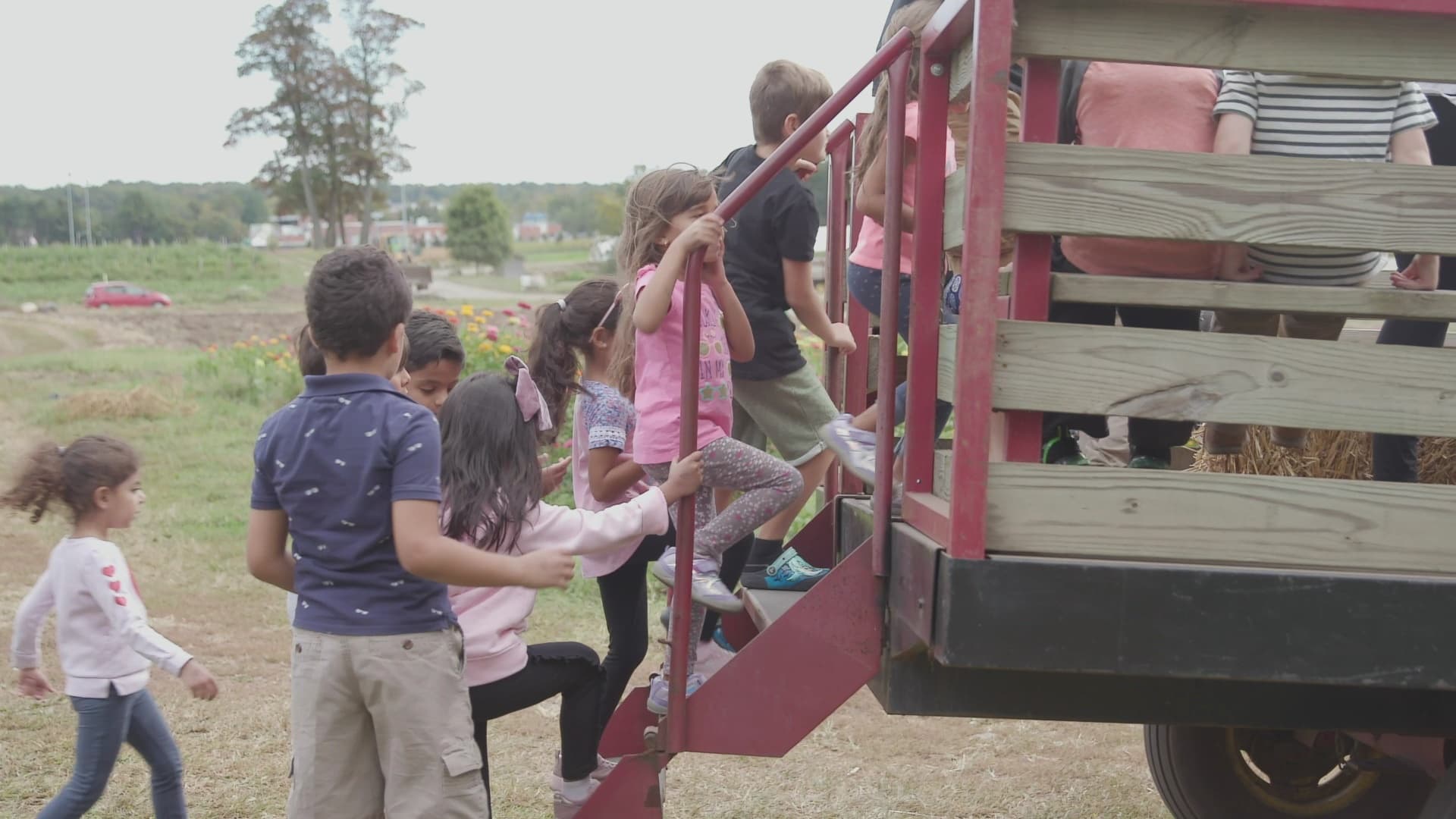 Children boarding farm wagon for hayride through abmasfarm fields
