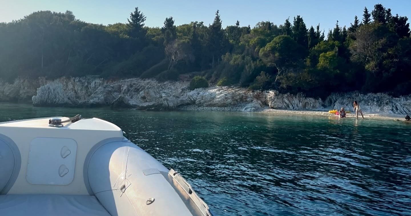 Inflatable boat bow approaching secluded rocky beach cove