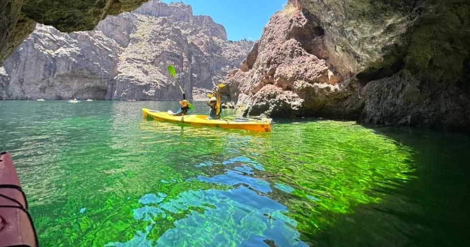 Bright yellow kayaks paddling through emerald canyon water