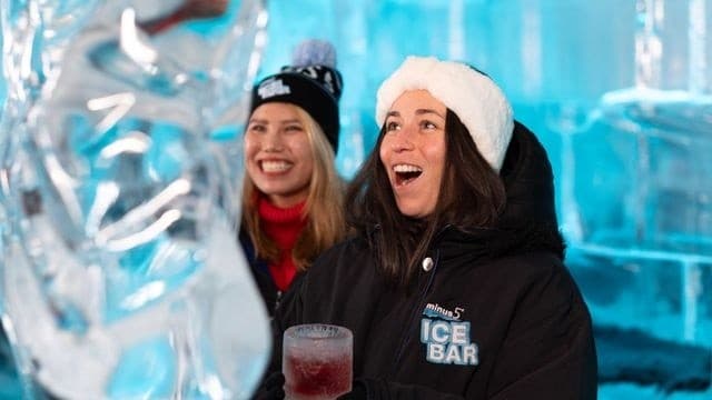 Friends laughing with drinks in minus5 ice bar icy interior