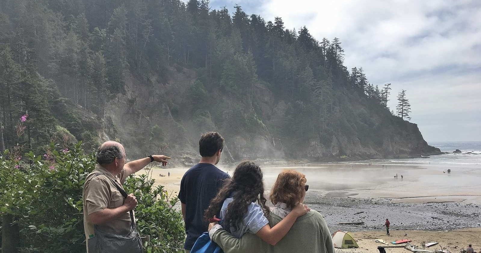 Group watching rugged Oregon coastline from bluff, beach lookout