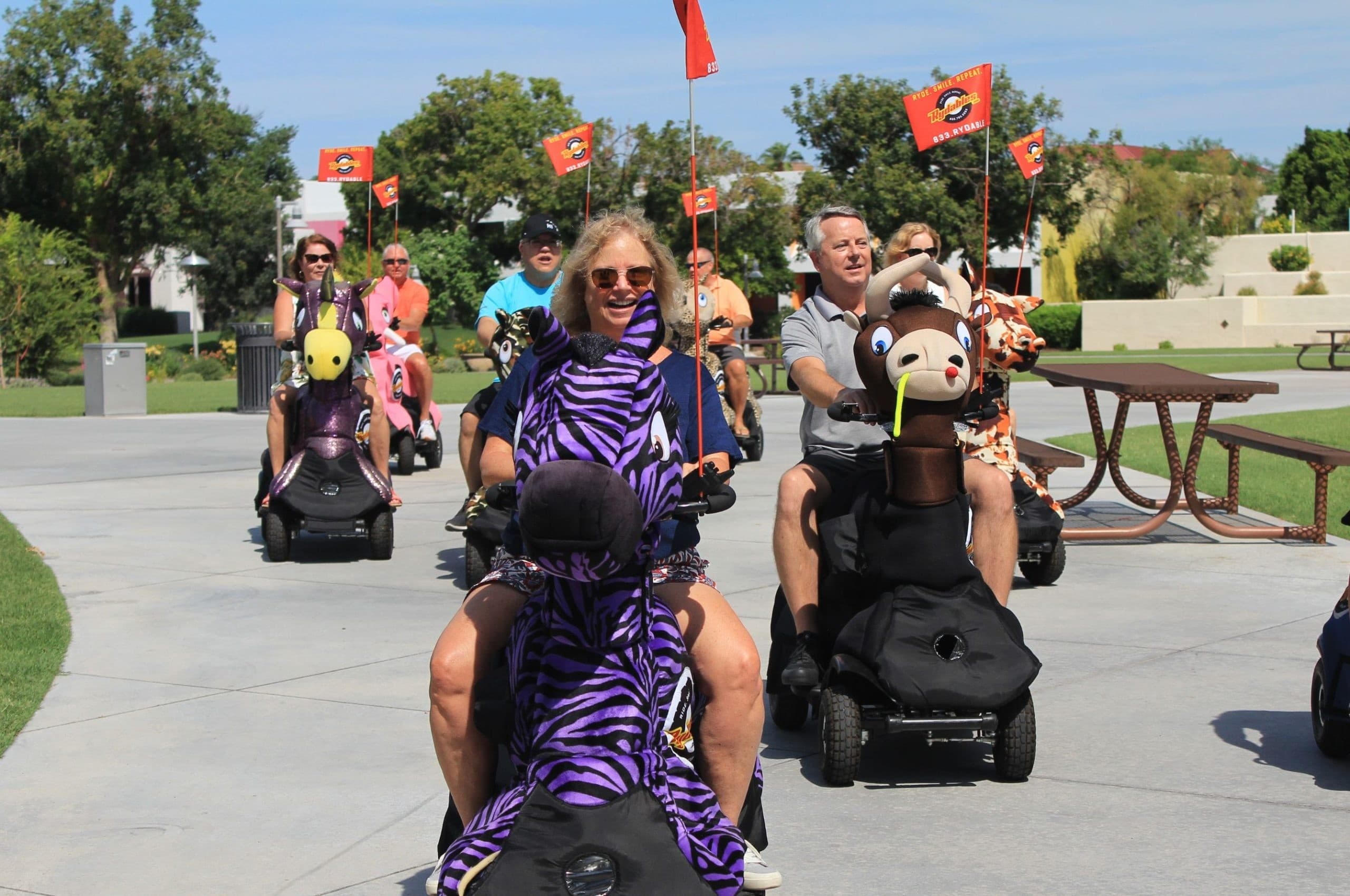 Park group riding themed mobility scooters on sunny Chicago promenade