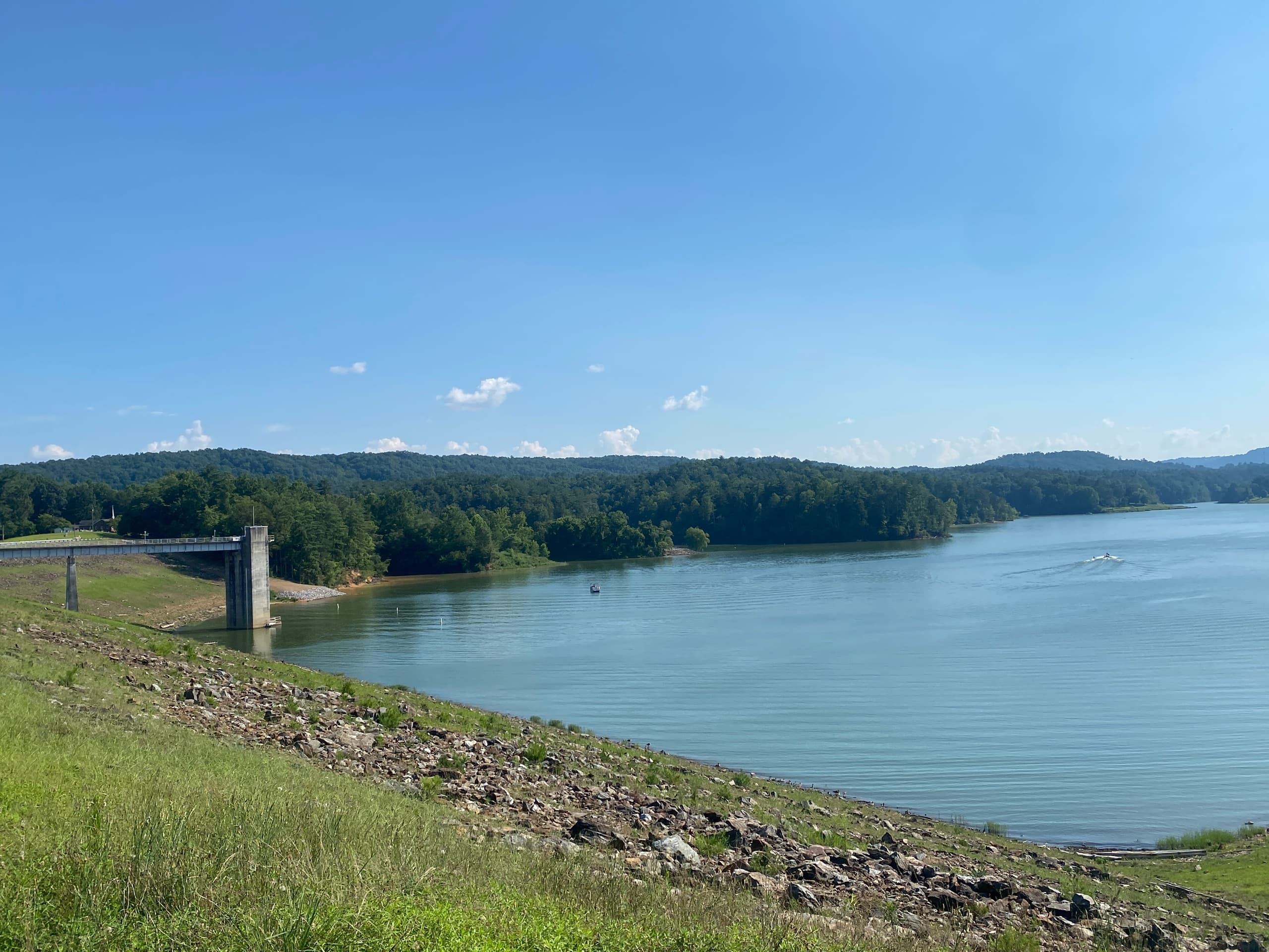 Scenic dam shoreline with grassy slope for lakeside hikes and views