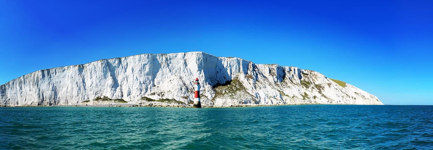 White chalk cliffs and lighthouse along Sussex coast boat trip