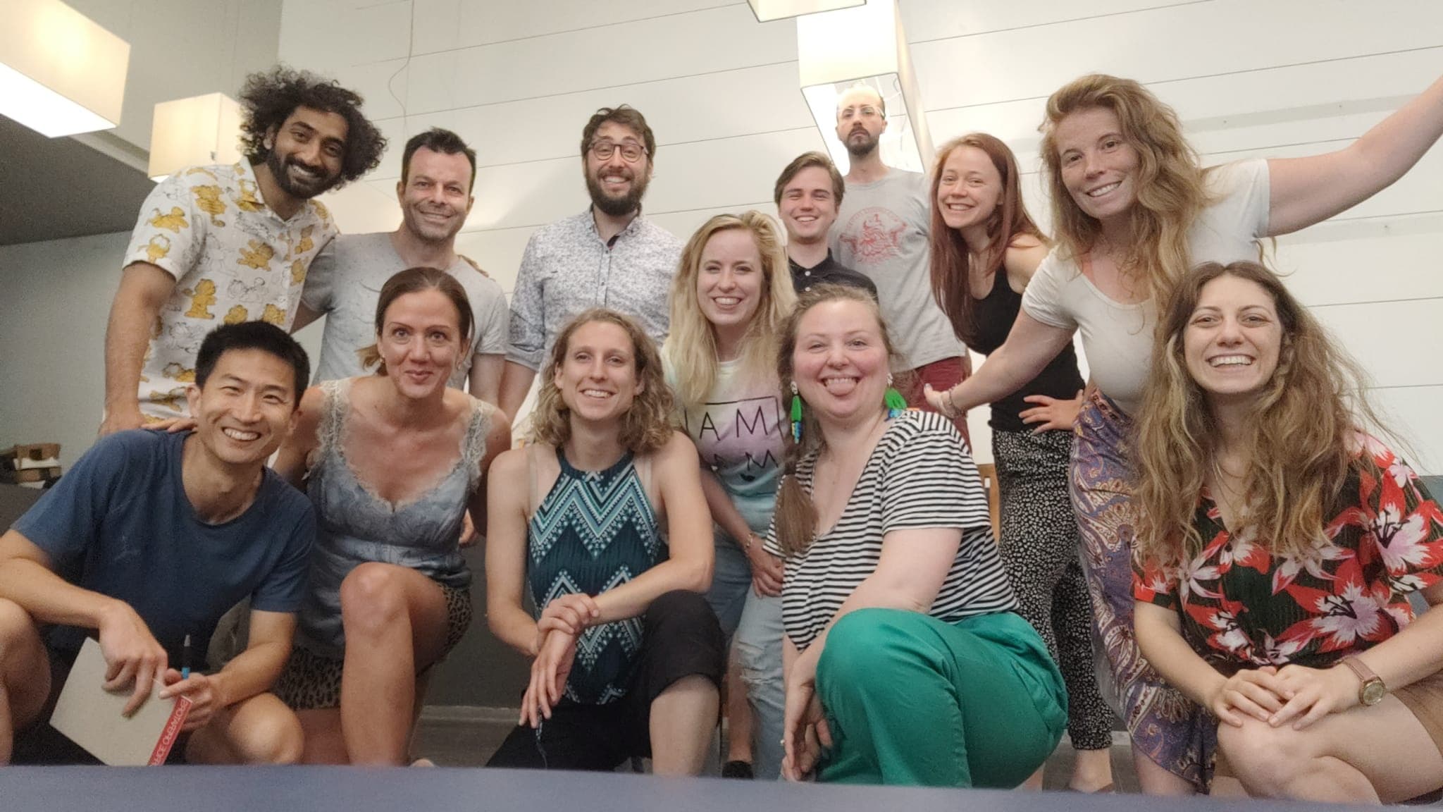 Group of improv students posing indoors in casual rehearsal space