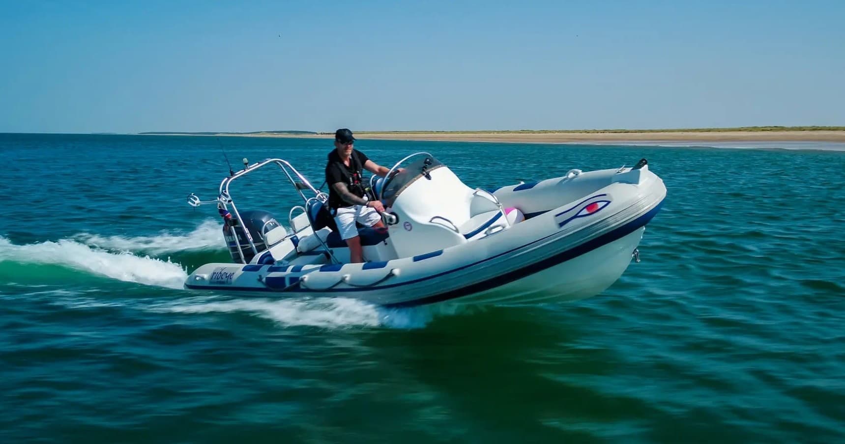 High speed rigid inflatable boat cutting through coastal waters