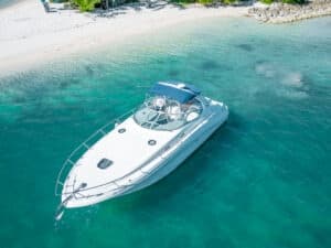 Aerial view of bow of yacht near sandy beach in clear tropical waters