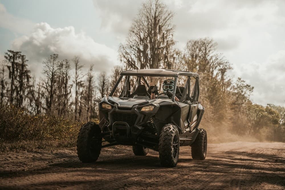 Off-road UTV kicking dust on scenic wooded Florida trail