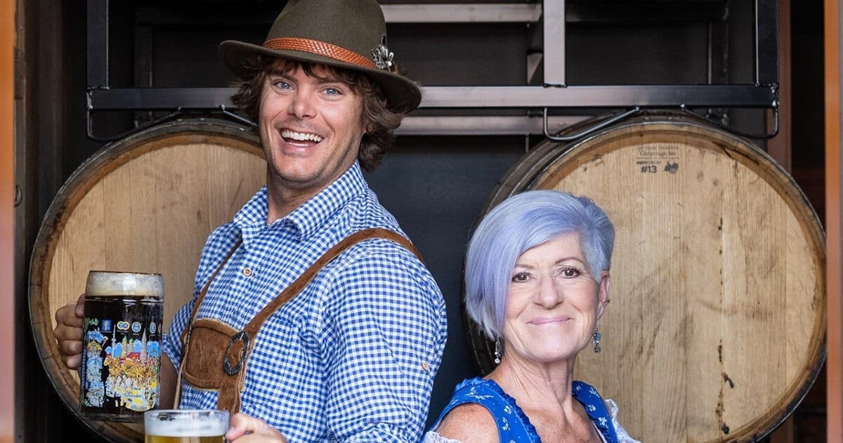 Couple posing with beer barrels inside Bavarian microbrewery
