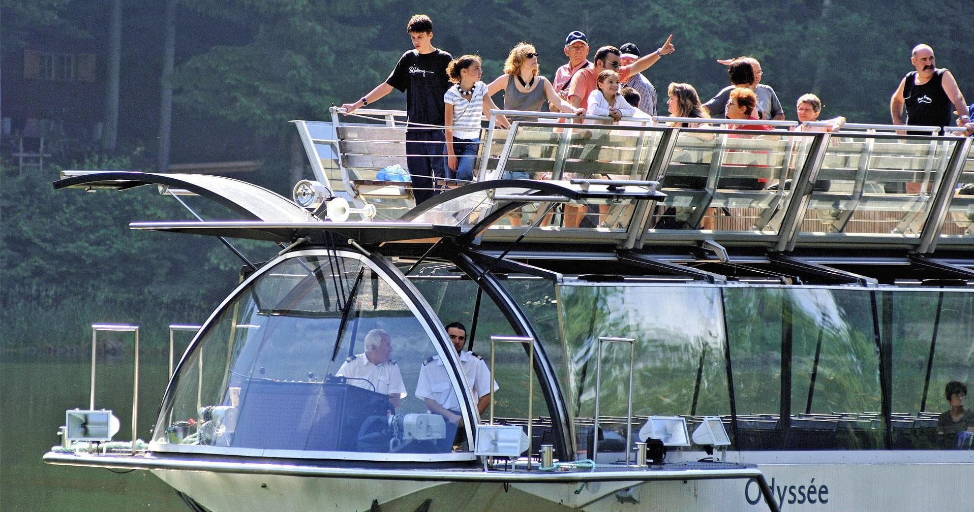 Panoramic glass-deck riverboat with passengers sightseeing