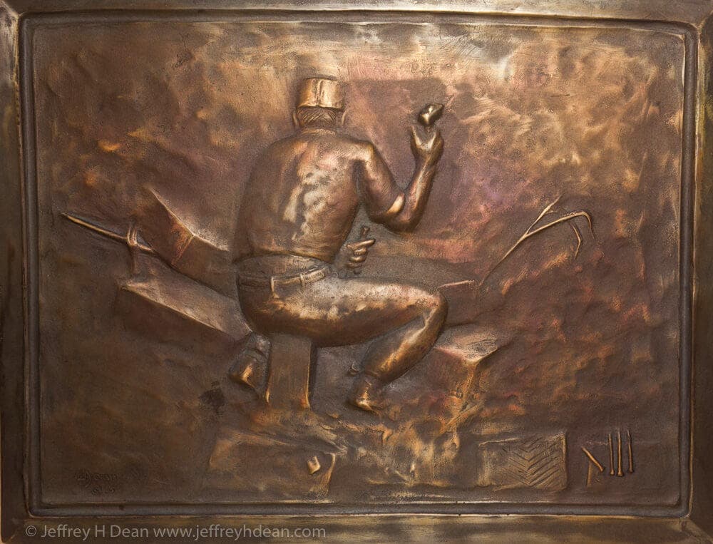 Bronze bas-relief plaque of a canoeist displayed on gallery wall