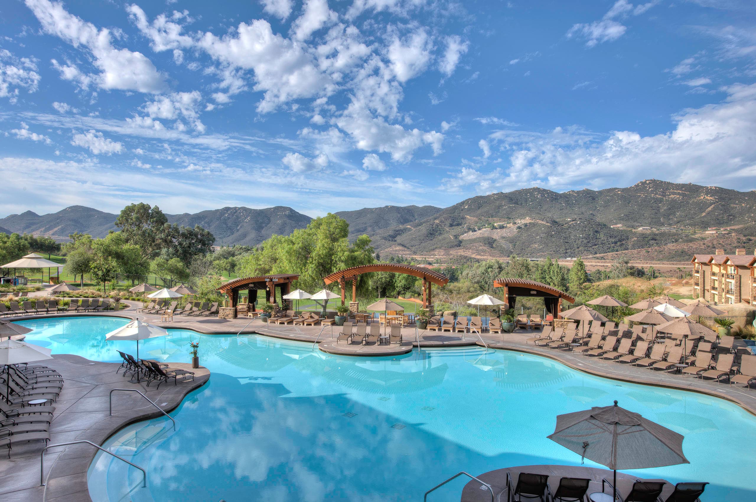 Luxury resort pool with mountain views and lounging areas