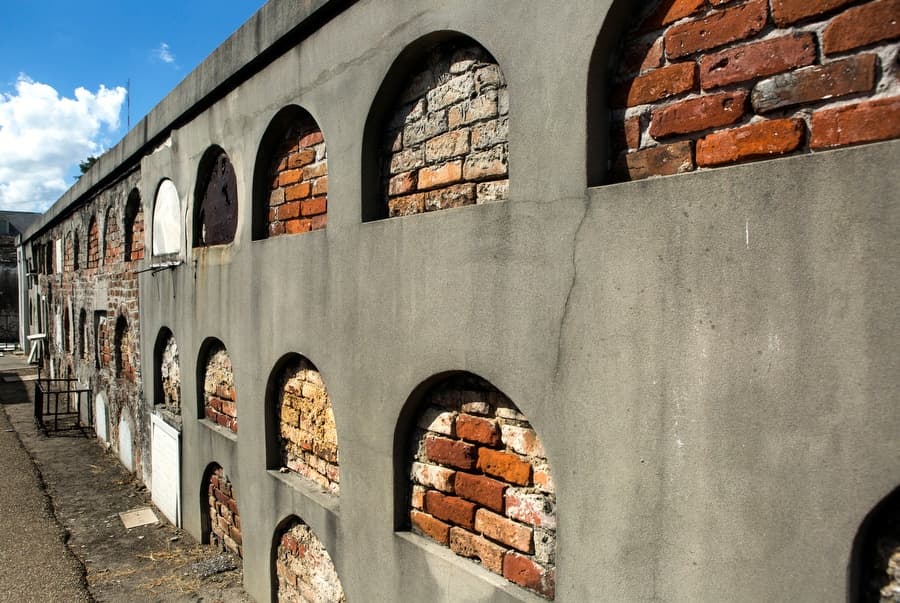 Arched columbarium wall with exposed brick in outdoor cemetery
