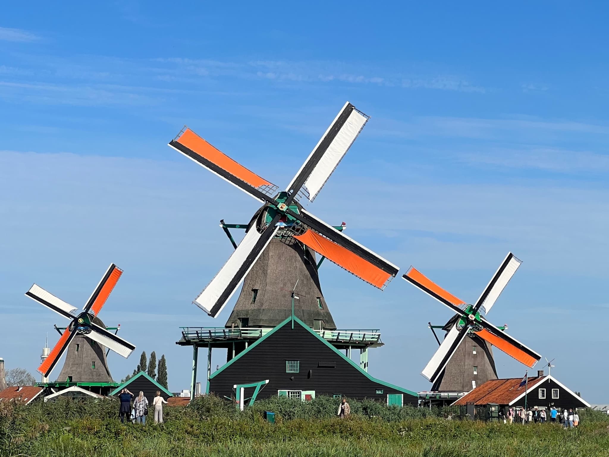 Visitors admiring historic Dutch windmills at Zaanse Schans