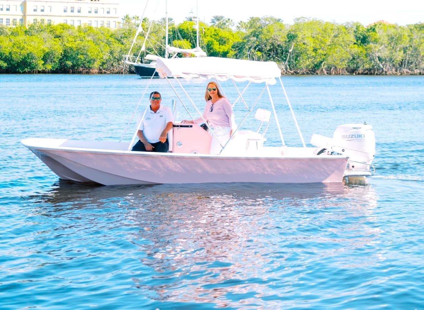 Couple piloting small center console boat in turquoise bay