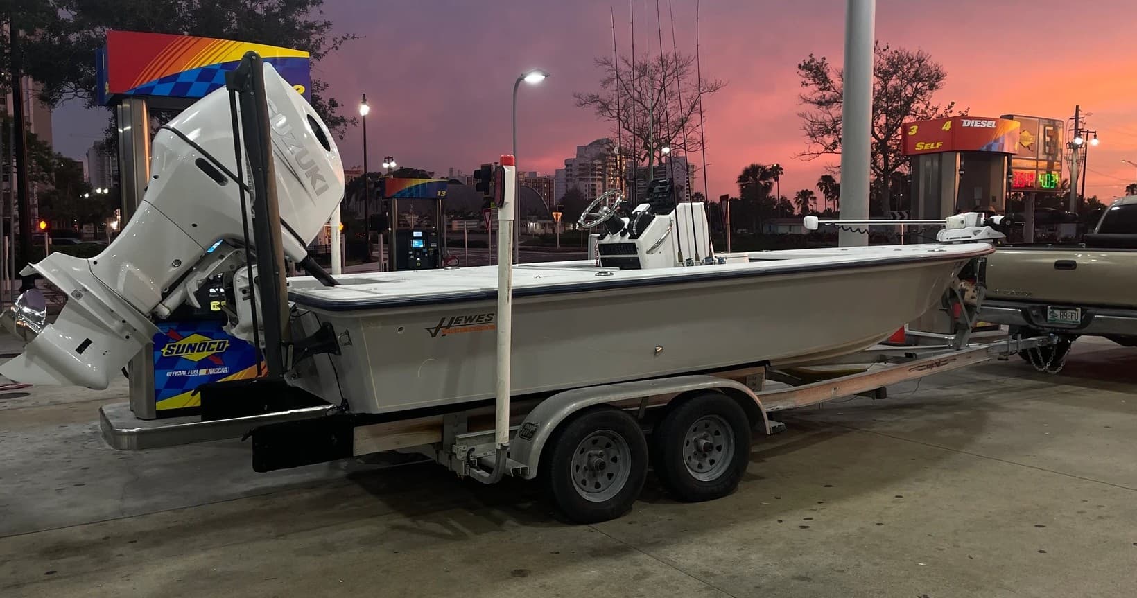Charter fishing boat on trailer at marina gas station sunset