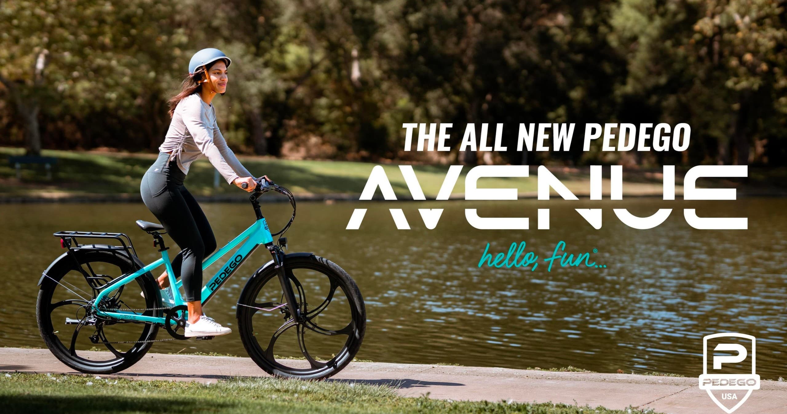 Woman on turquoise Pedego electric bike by lakeside park