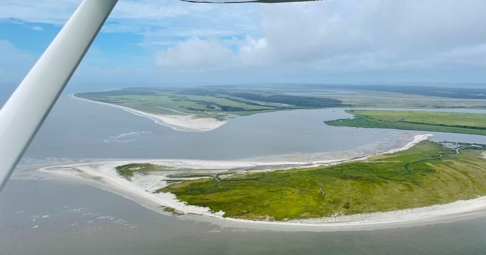 Aerial passenger flight view over tidal inlets and sandbars