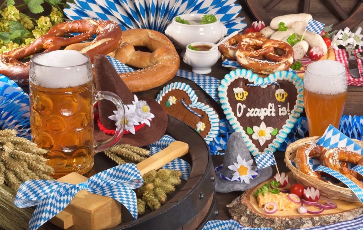 Oktoberfest spread with beer steins and pretzels on table