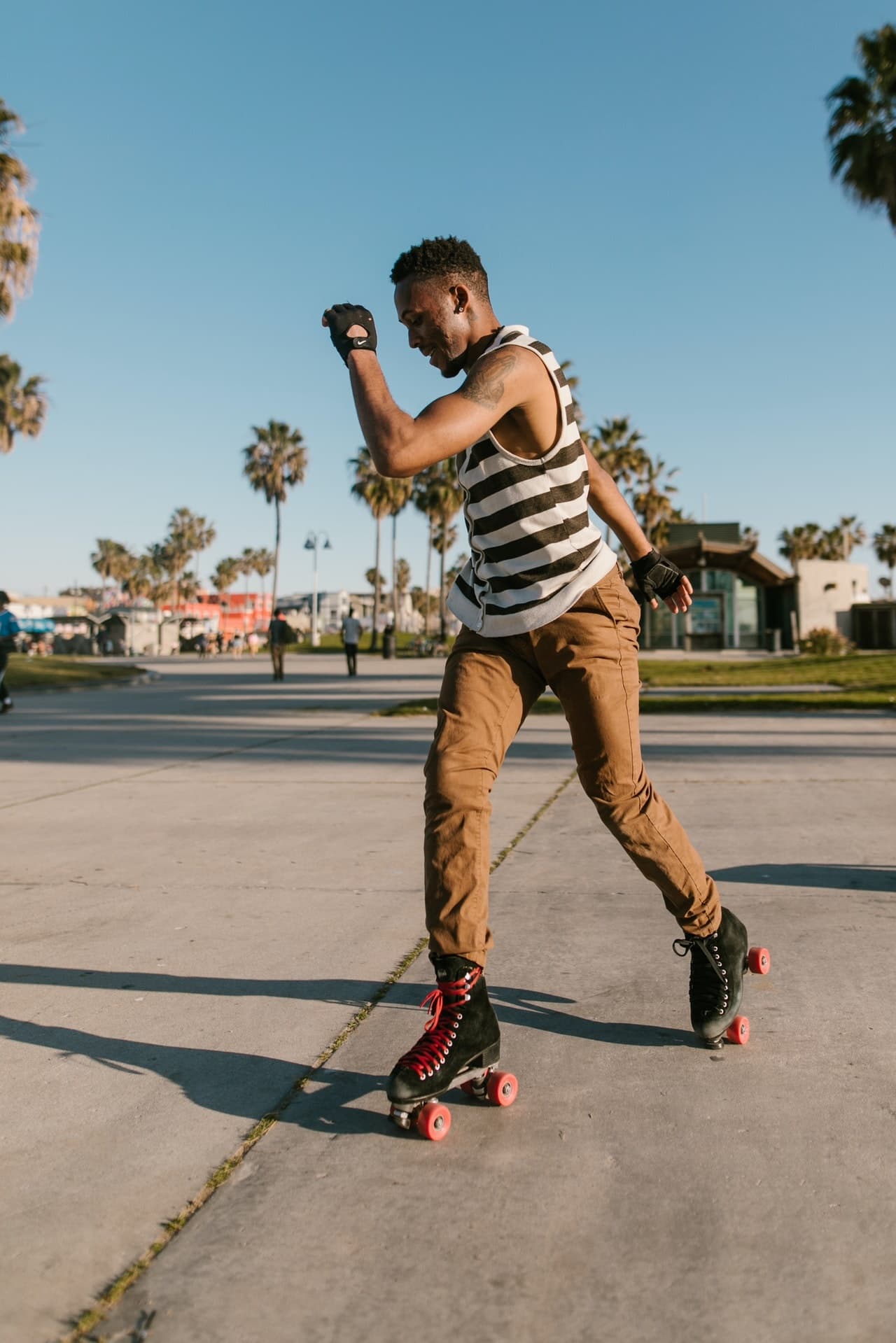 Man rollerblading on sunny boardwalk practicing outdoor tricks