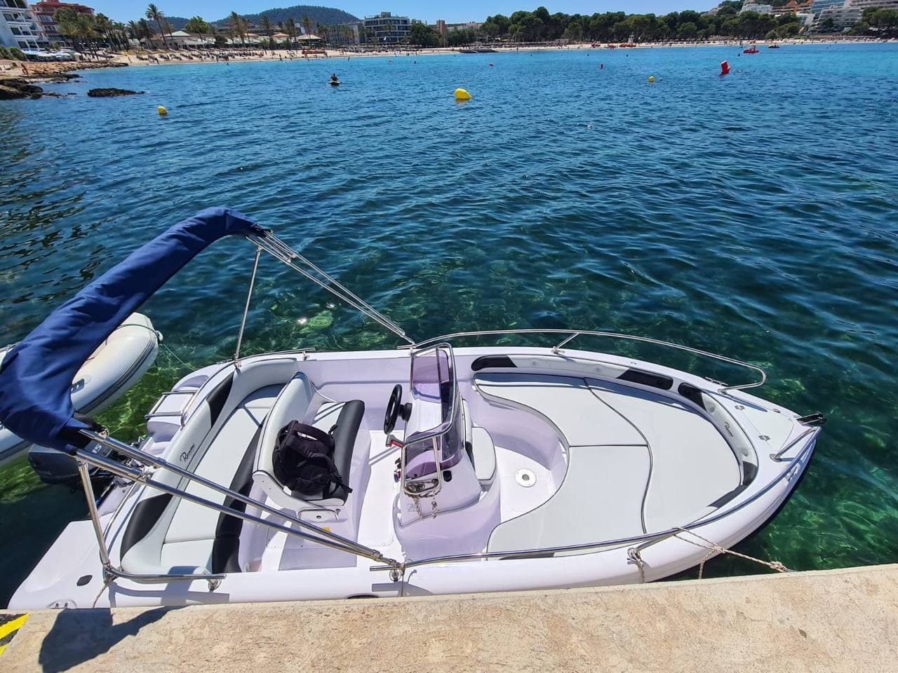 Small motorboat moored in clear turquoise bay near shore