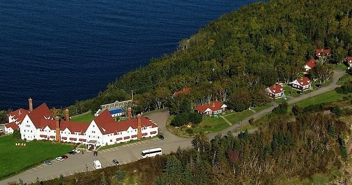 Aerial view of coastal resort and forested shoreline by ocean