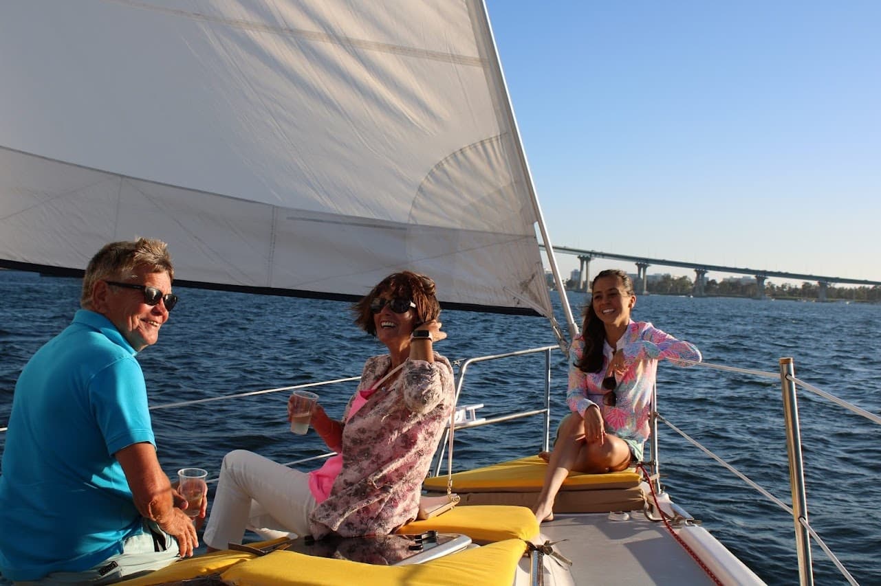 Sailboat cruise under full sail near San Diego Bay bridge