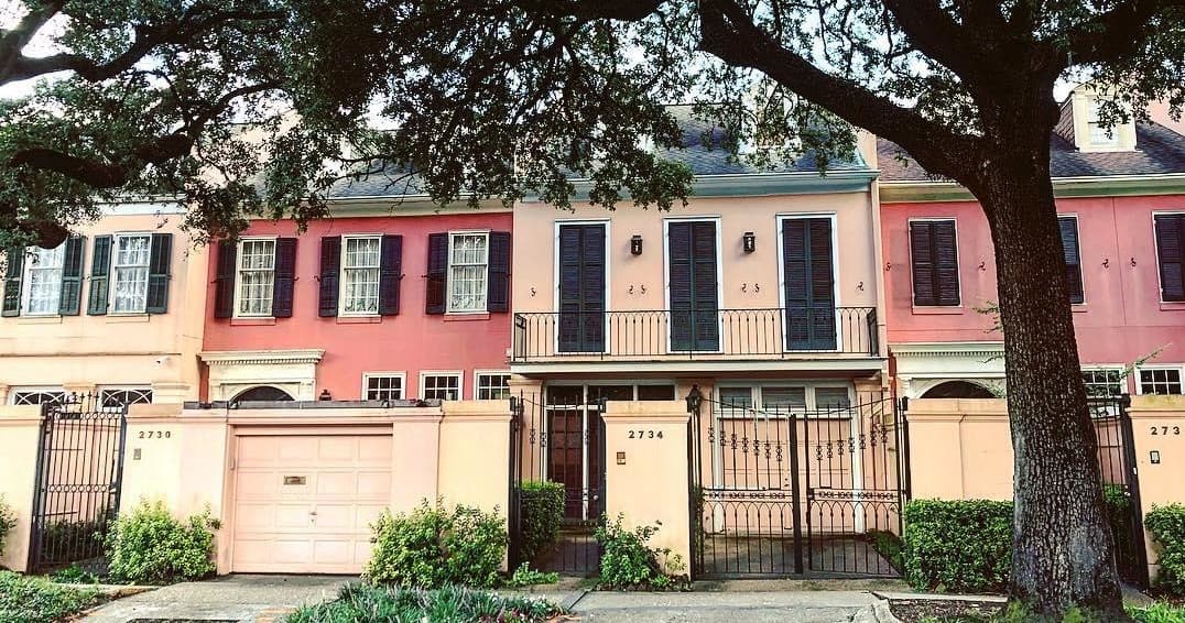 Colorful historic townhouse row with live oaks, New Orleans street