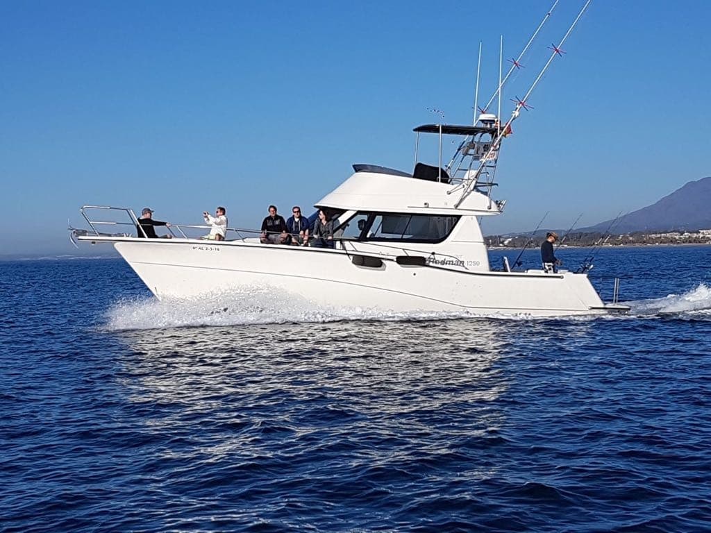 Sportfishing charter boat cruising coastal waters with crew