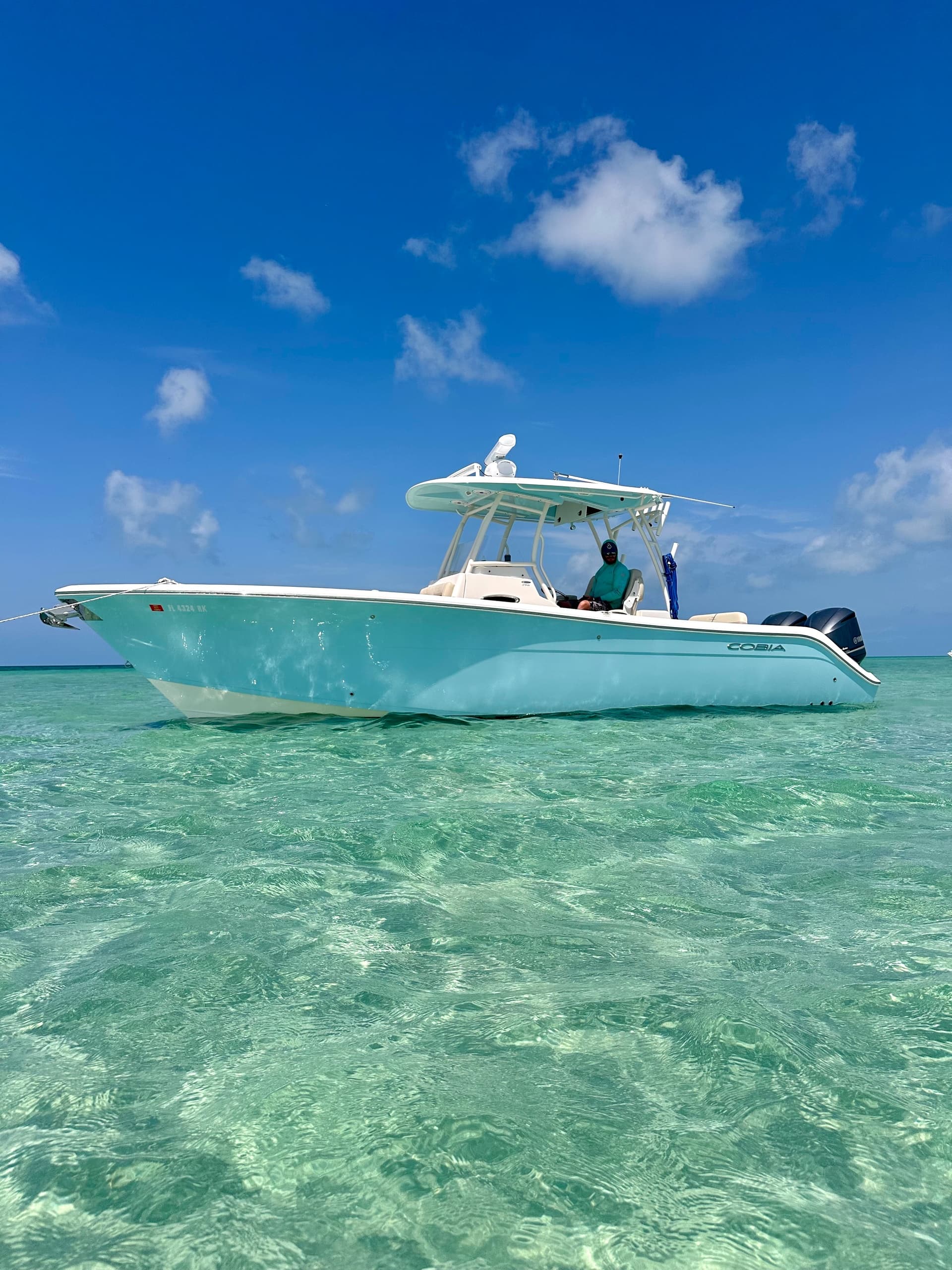 Center console boat anchored in shallow crystal-clear turquoise water